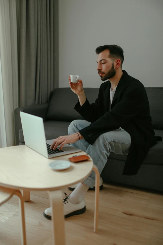 a man with a laptop and a coffee cup