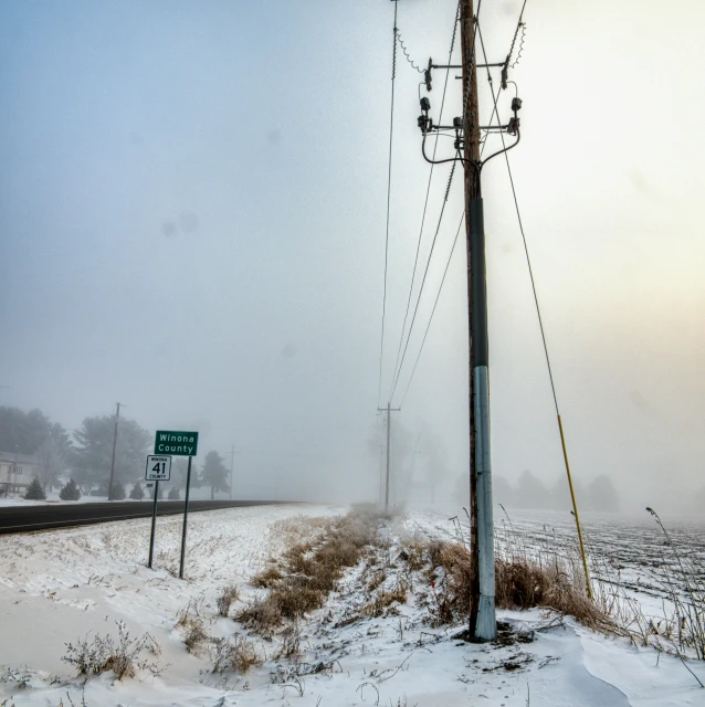 street signs on the side of a road in snow