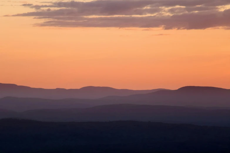 a mountain side that looks like it has an orange sunset