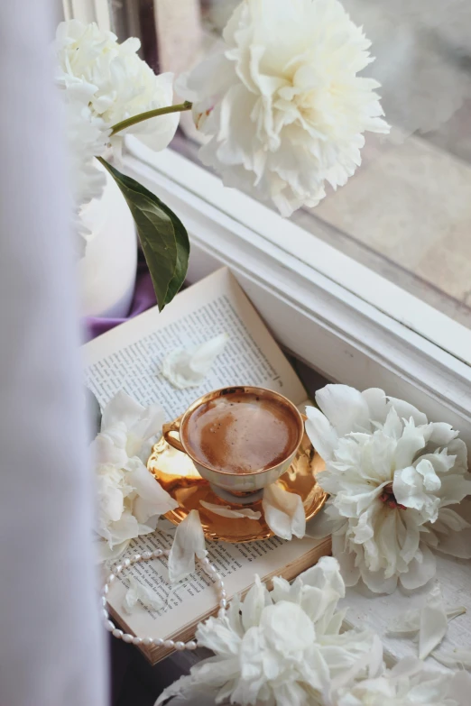 the book and vase are next to the cup