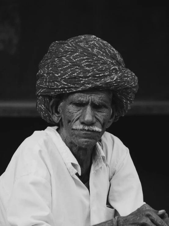 a man with a hat and a tie is looking at the camera