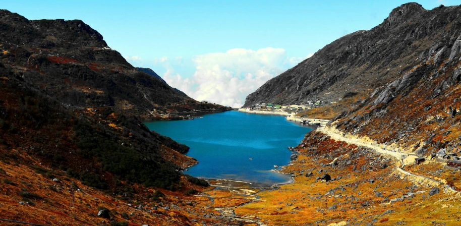 a lake sits between two mountains covered in grass