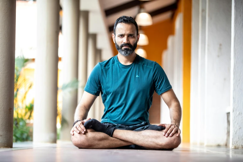 man with goatee sitting in the middle of a meditation position