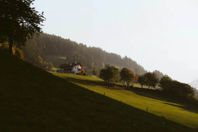 house and lot in the foreground on a hilltop covered with lush green grass