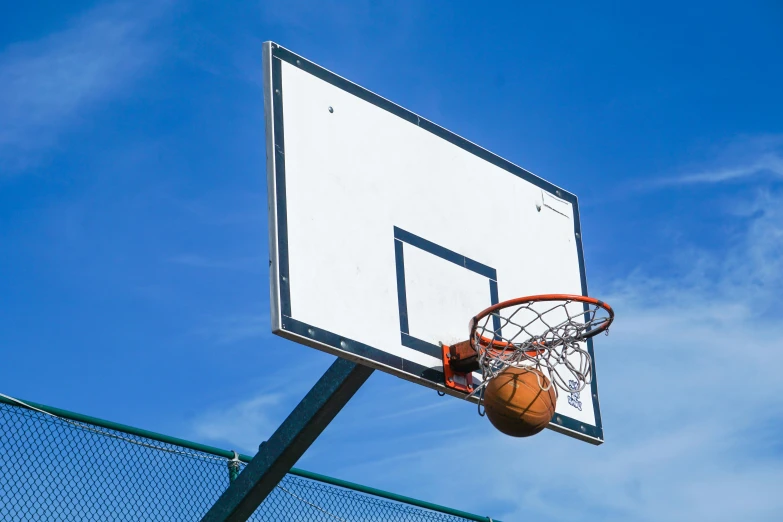 a basketball is stuck inside the rim of a basket