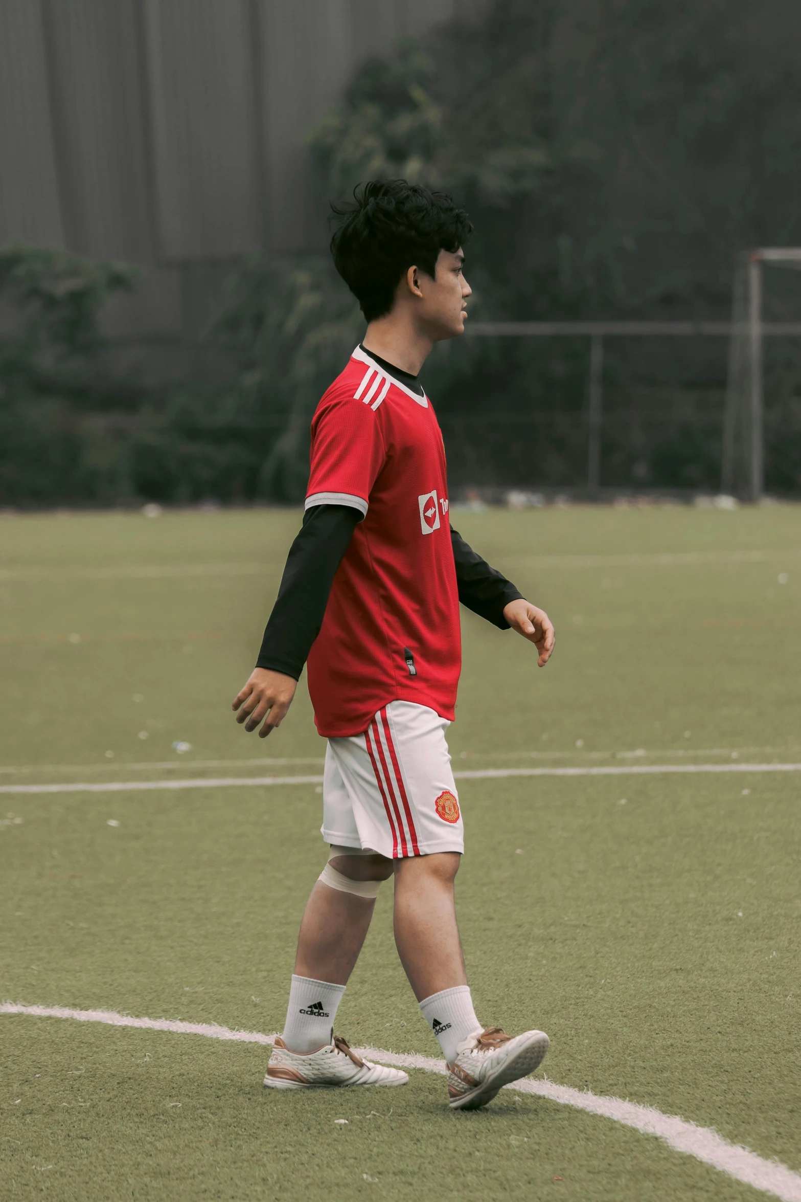 a boy standing on a field holding a frisbee