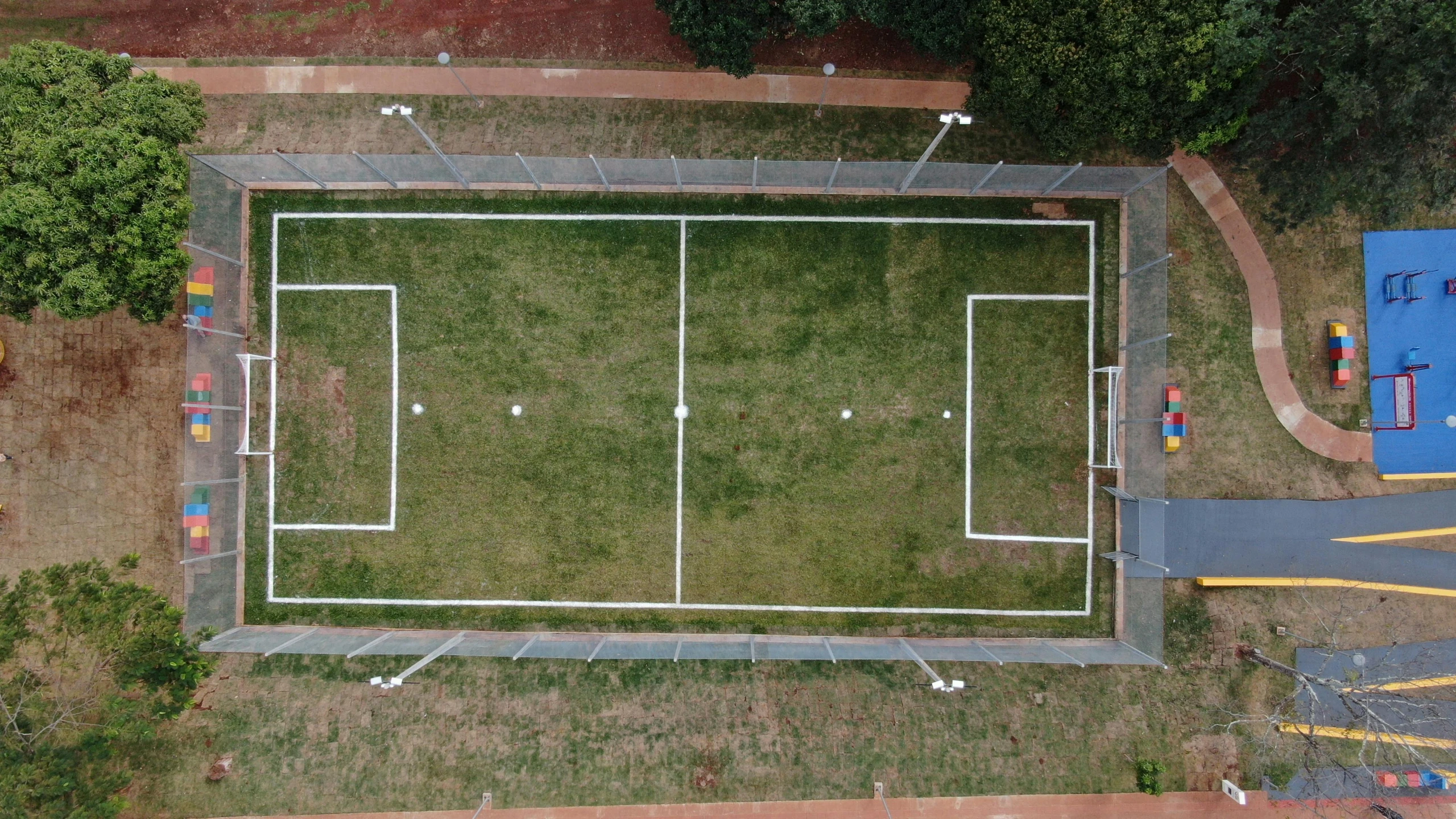 a tennis court with a grassy lawn and many colored markers