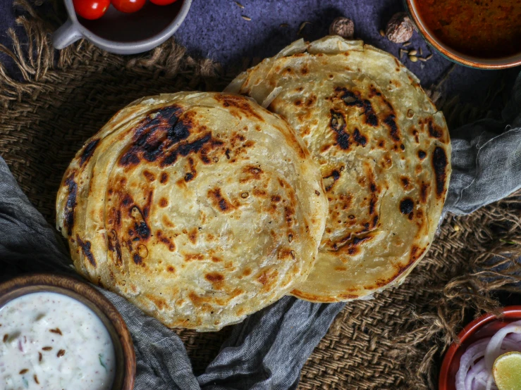 two pita breads and some sour sauce