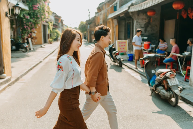 an asian man and woman walking through the street