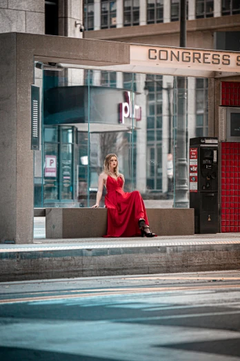 woman sitting in front of a el window on a city sidewalk