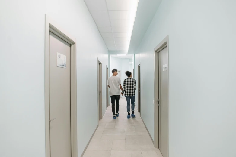 two people stand in a hallway leading to elevators