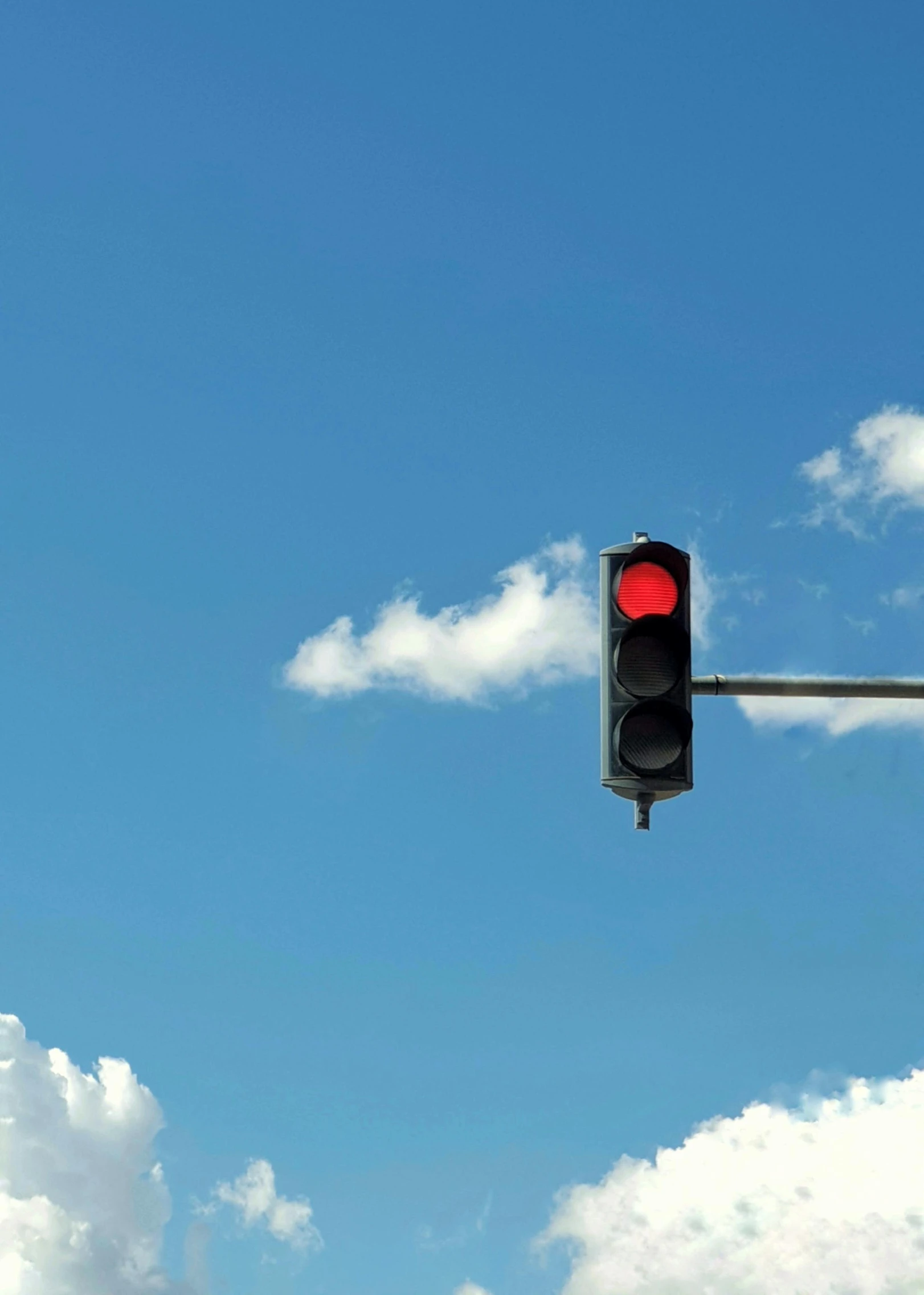 the traffic light is red against a blue sky