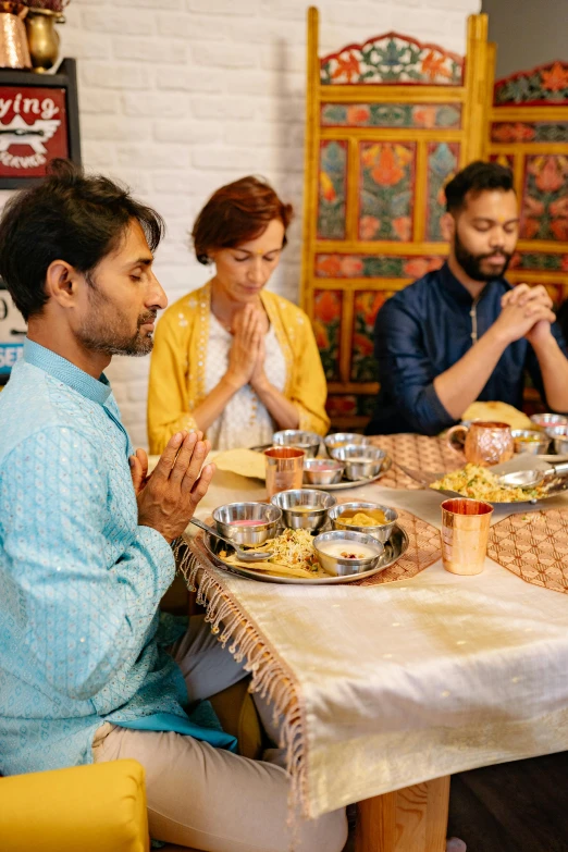 people are sitting at the table during a meal