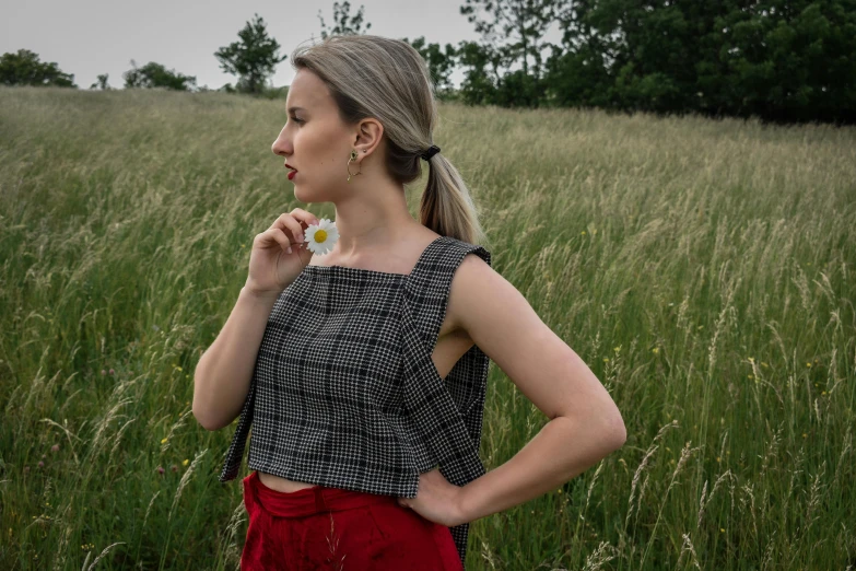 a woman is standing in a field looking into the distance