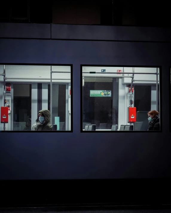 the reflection of people in a window at night