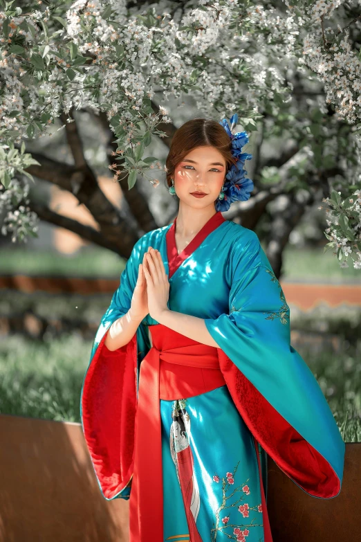 a woman dressed in chinese art with a flowery hairdoodle under a tree