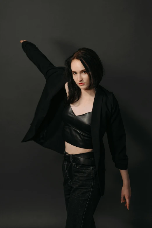 a woman is standing in black jeans and a jacket