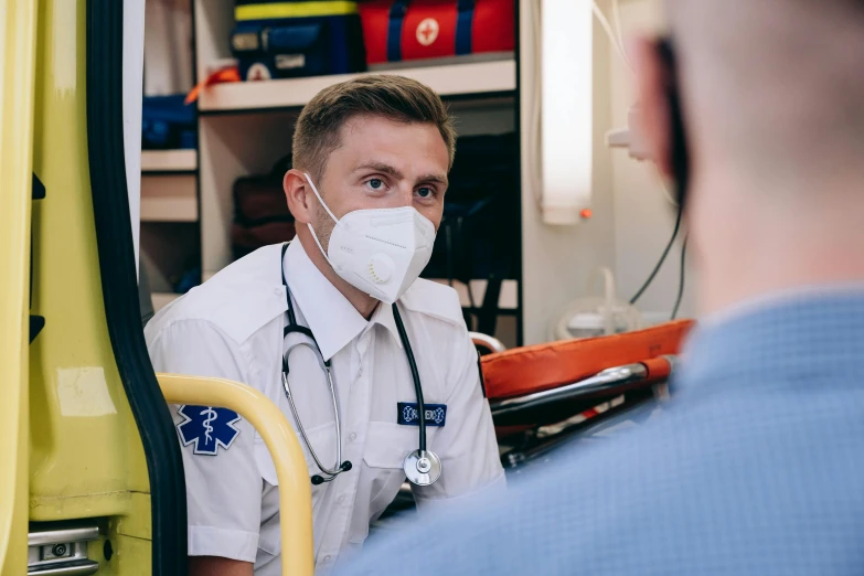 two medical personnel are at the wheel of a yellow truck