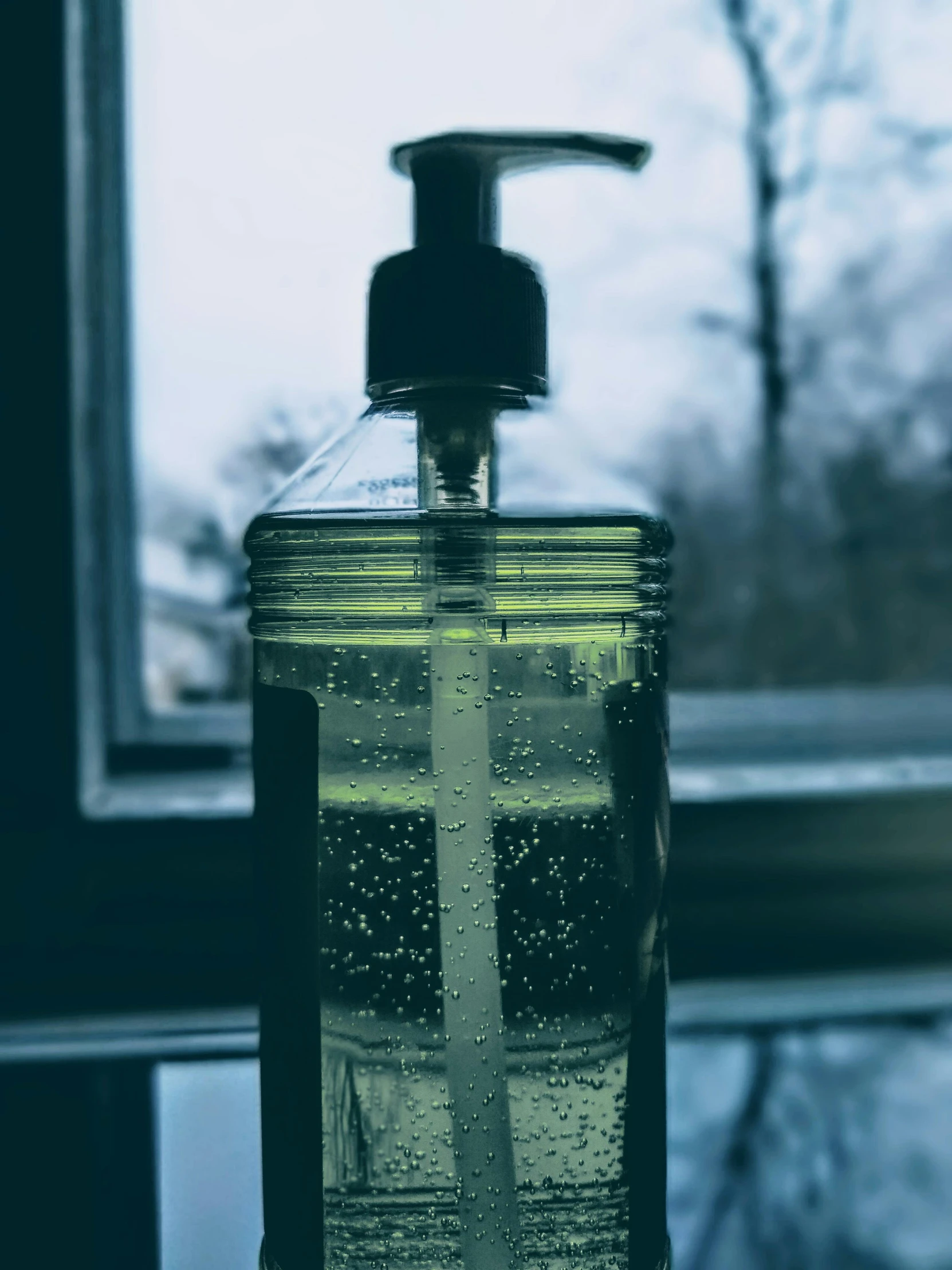 a soap dispenser sitting next to a window