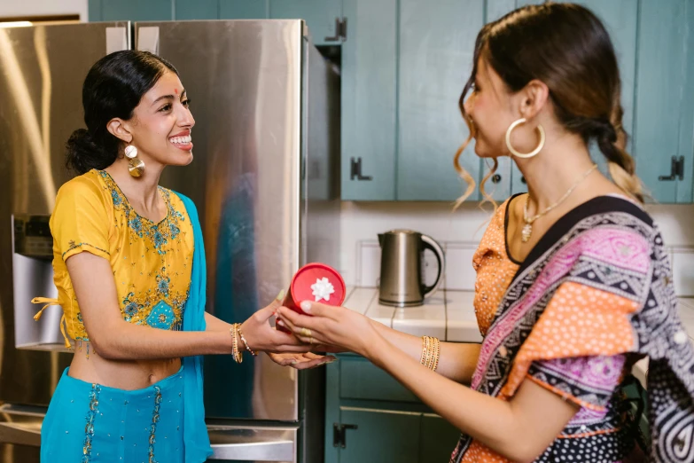 a couple of women that are standing in front of a refrigerator