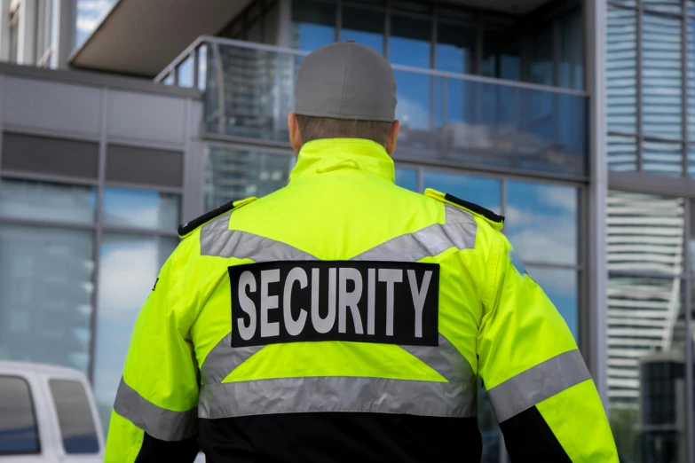 a security officer in front of a building and some cars