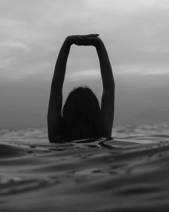 a person in the water with her hands up