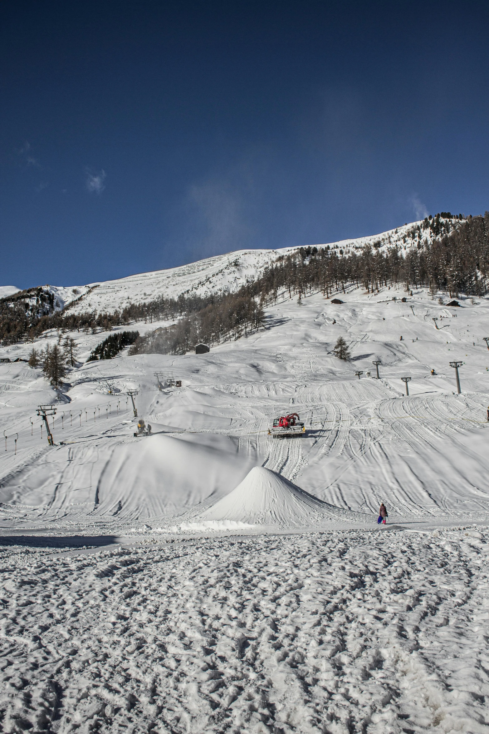 a ski slope with several skiers and snow covered ground