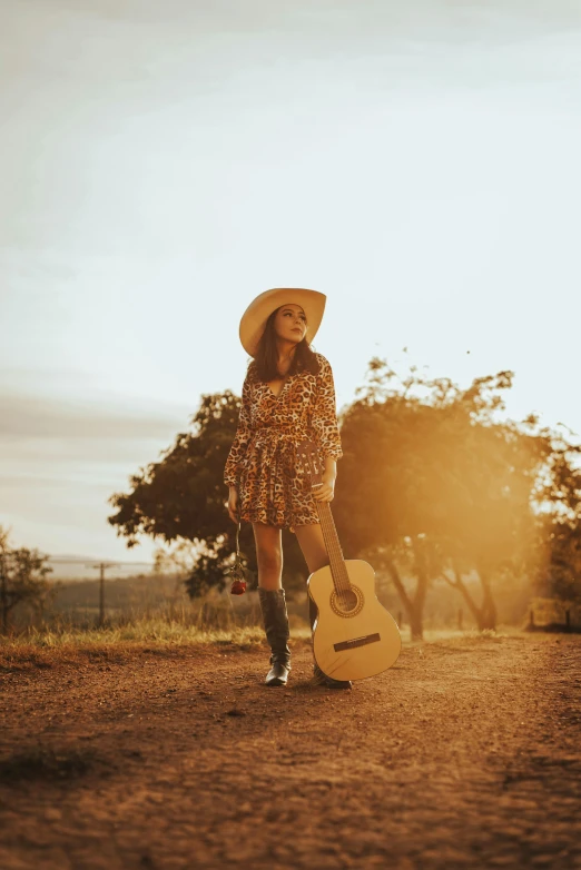 a woman with a guitar walking down the road