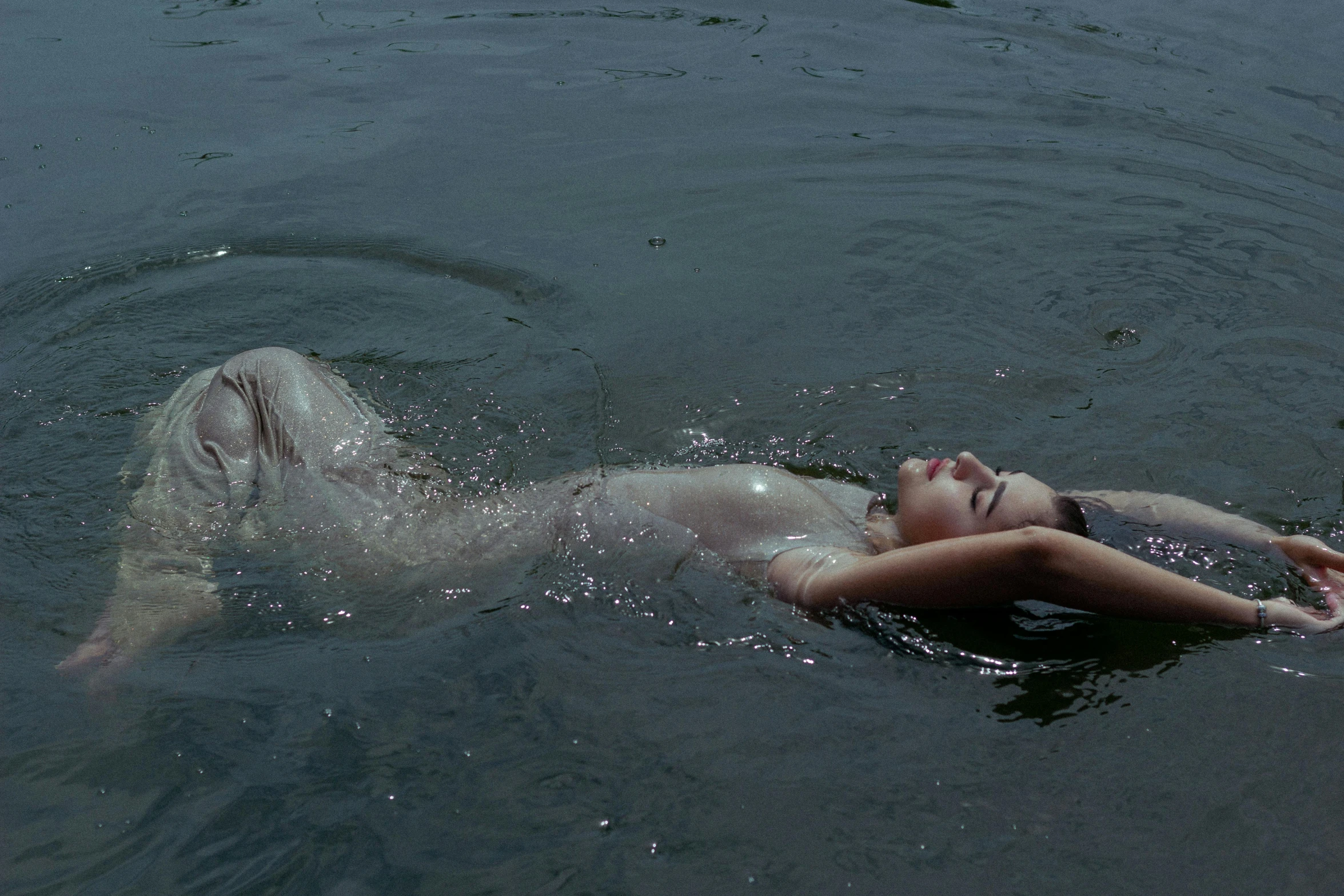 an adult girl laying in the water