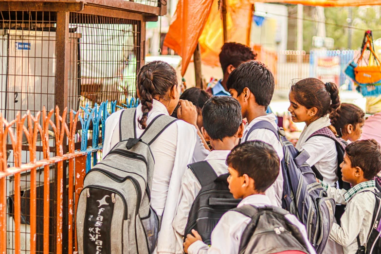 a group of children standing in a line to get their luggage