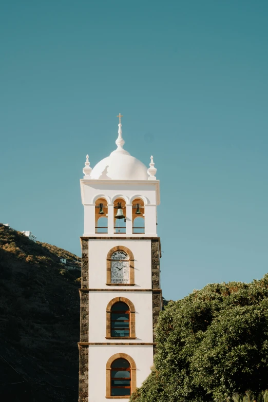 a large white clock tower under a blue sky