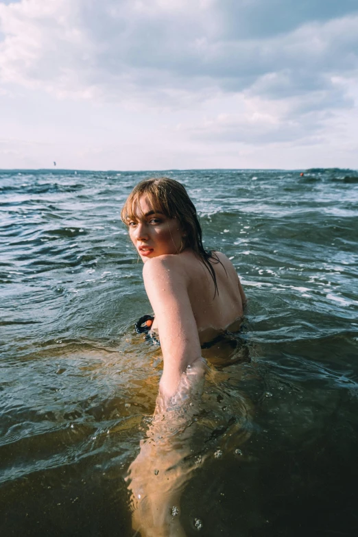 a woman in the ocean with her shirt on