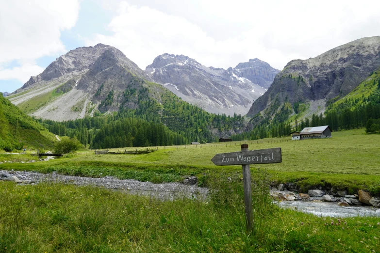 a beautiful scenic scene with a small creek and mountains