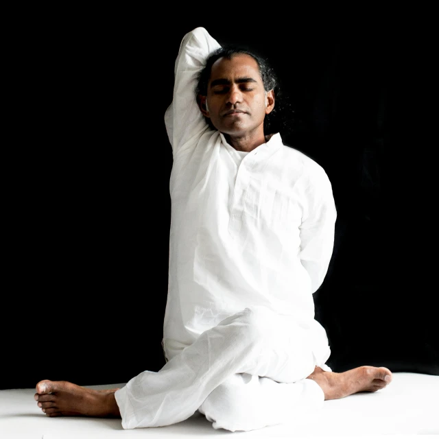 a man sitting on the ground in white clothes