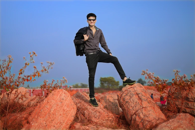 a man standing on top of rocks with a backpack