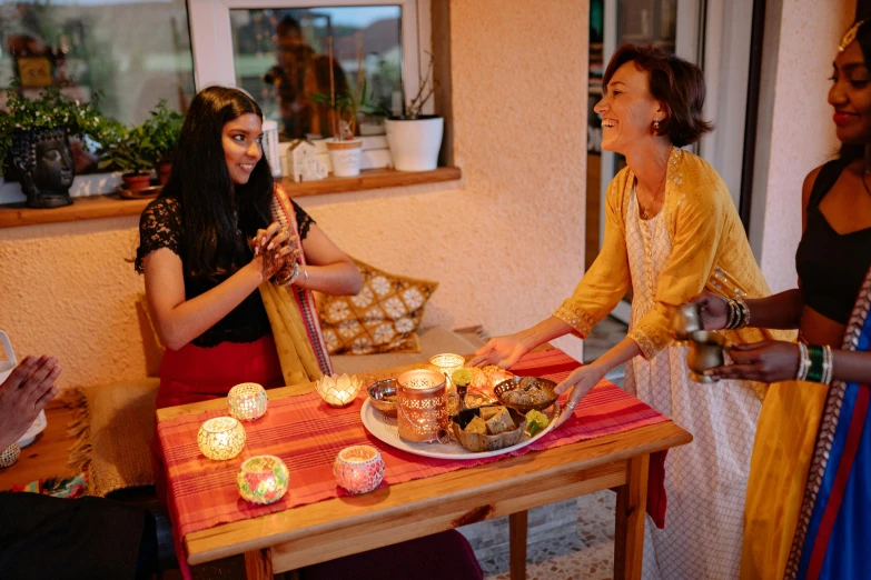 a group of people around a table celeting with food