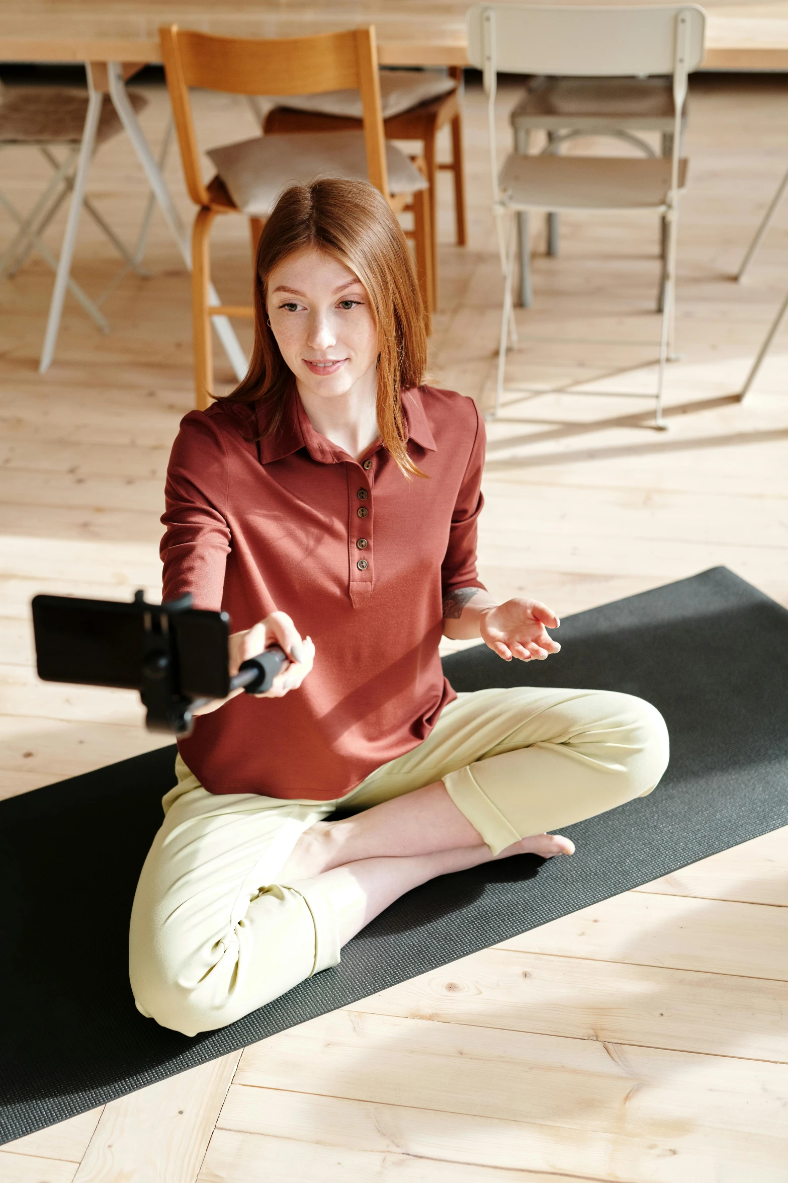 a girl sitting in a lotus yoga pose and holding out her right hand