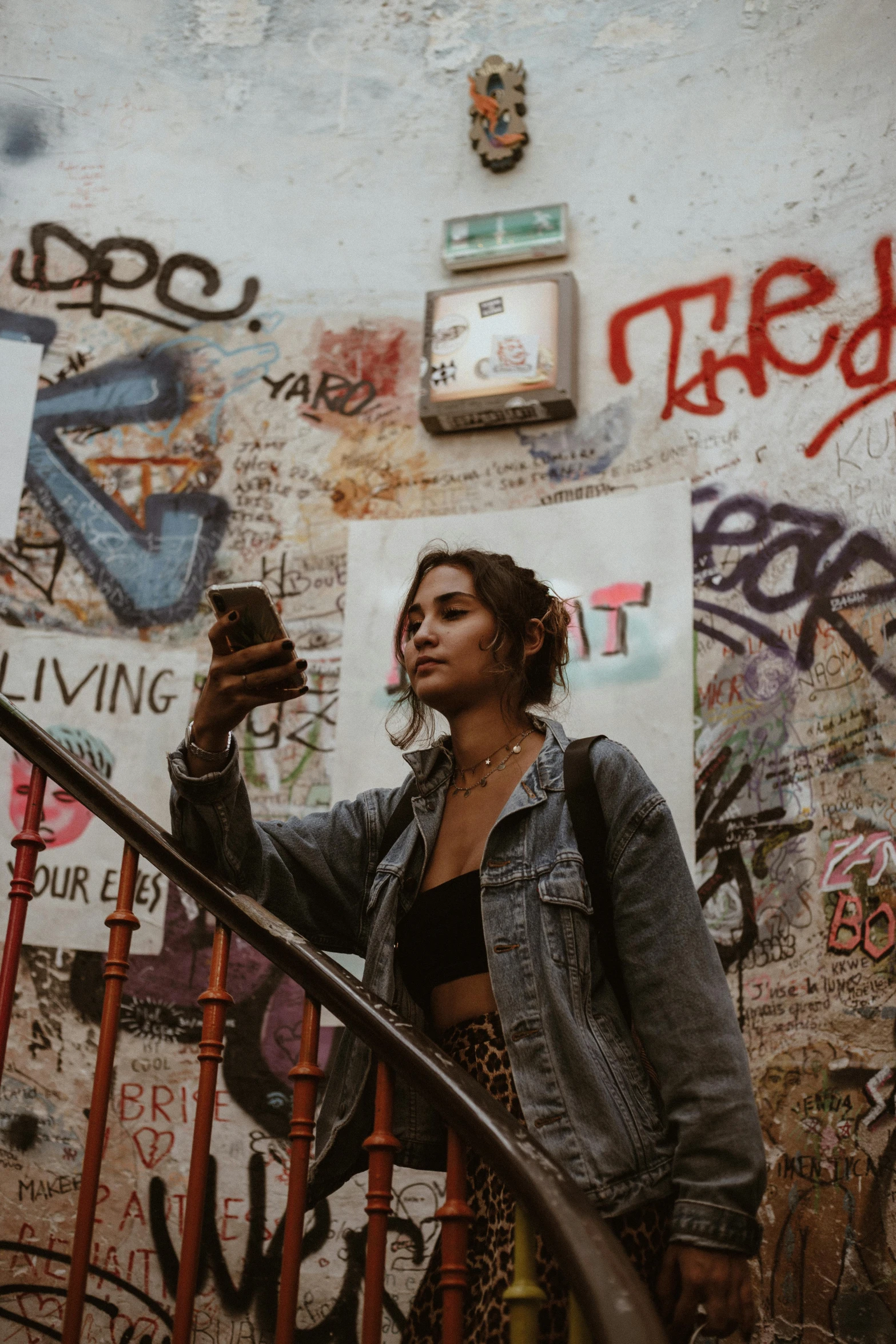 the young woman is walking up the stairs holding a cell phone