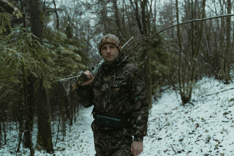 a man standing in the snow holding a sgun