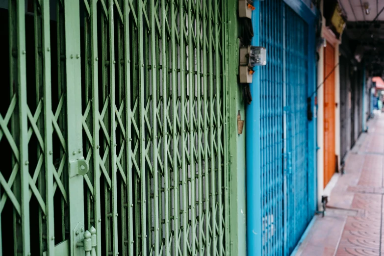 a green gate next to a blue building