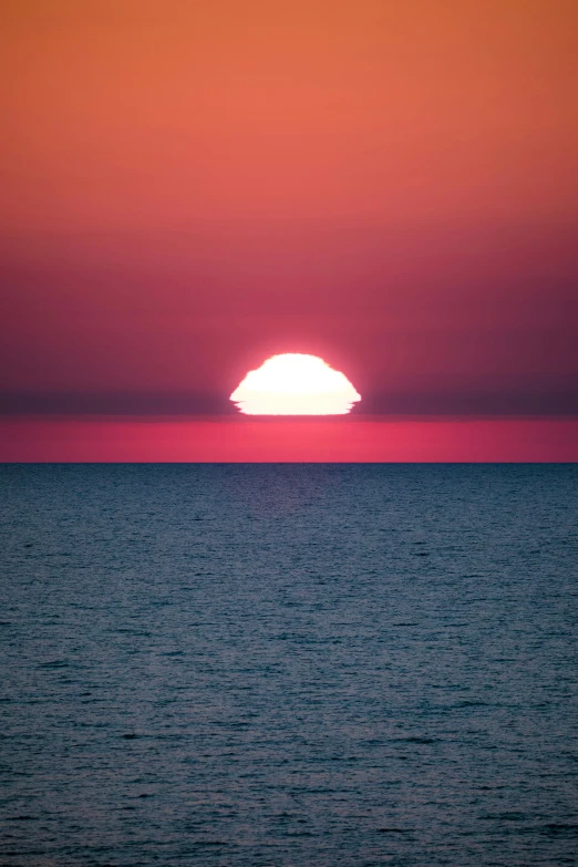 the sun is setting over water with it's reflection