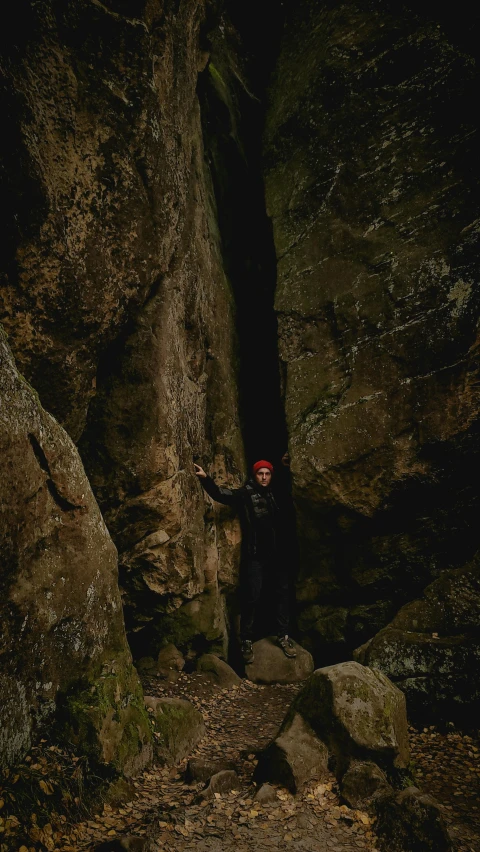 a person with their arms raised standing on the edge of a cliff