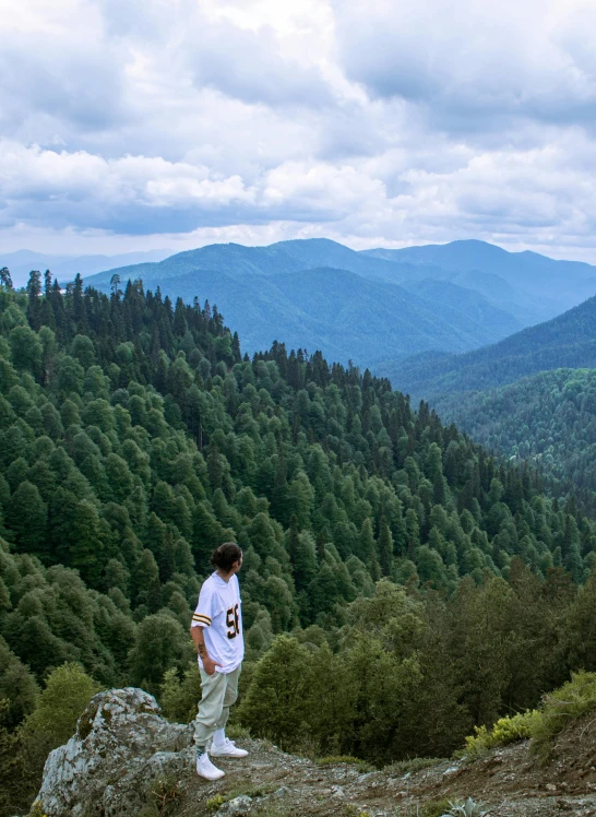 a man standing at the top of a mountain on a cliff