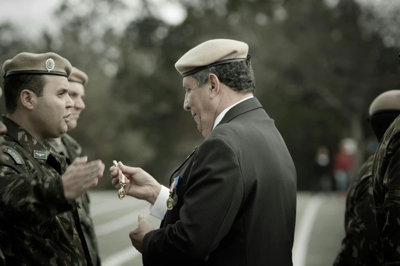 two men in suits standing together, one man is pinning his finger to the other man's hand