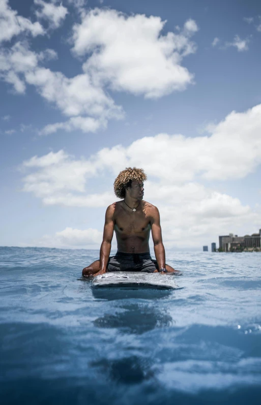 a man sitting on his surfboard in the water