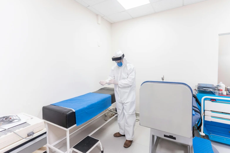 a man in white is standing next to a hospital bed