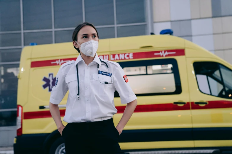a man standing next to an ambulance wearing a face mask