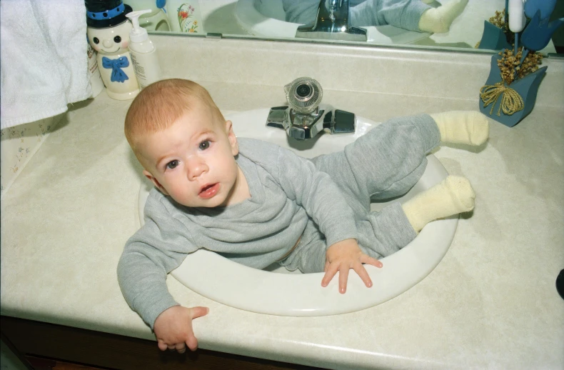 a baby in a sink posing for the camera