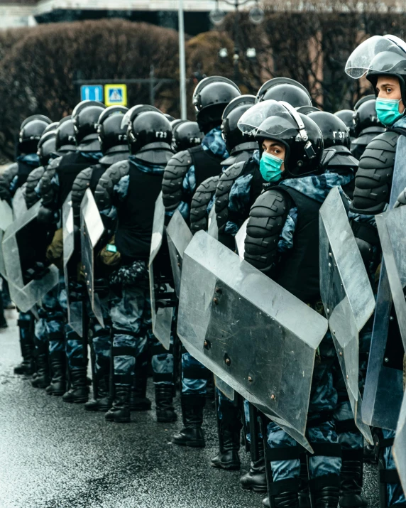 a bunch of police standing in line with shields