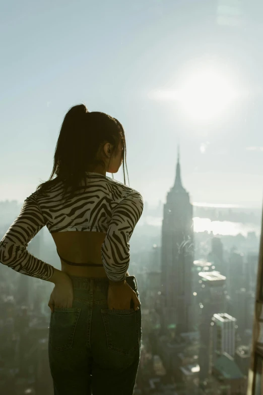 the woman in striped shirt is standing near large city